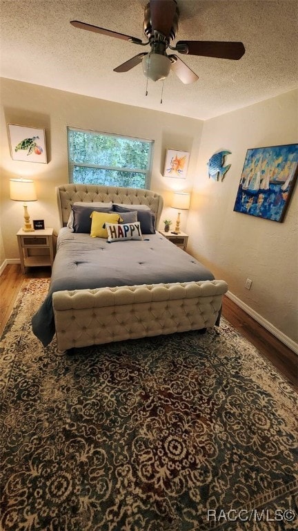 bedroom with wood-type flooring, a textured ceiling, and ceiling fan