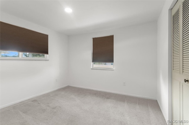 unfurnished bedroom with light carpet and a closet