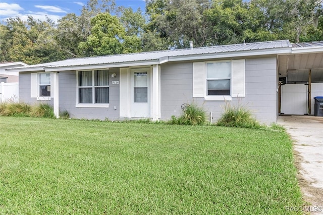 ranch-style home with a carport and a front lawn