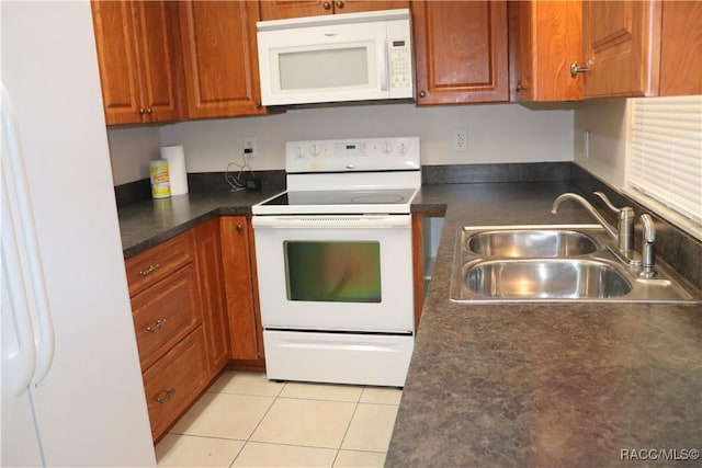 kitchen featuring sink, light tile patterned floors, and white appliances