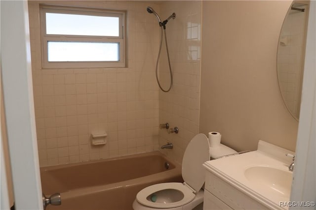 full bathroom featuring vanity, tiled shower / bath, and toilet