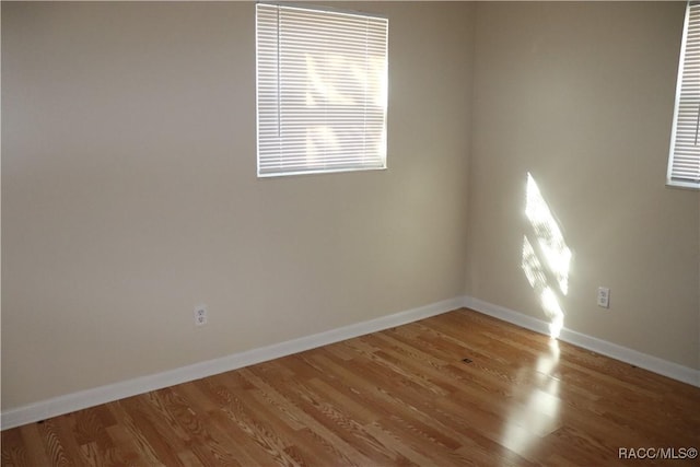 unfurnished room with hardwood / wood-style flooring