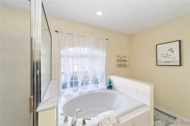 bathroom featuring a relaxing tiled tub