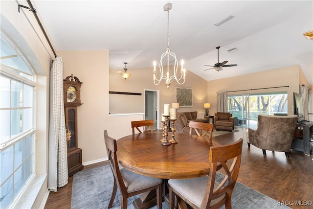 dining space with lofted ceiling, ceiling fan with notable chandelier, and dark hardwood / wood-style floors