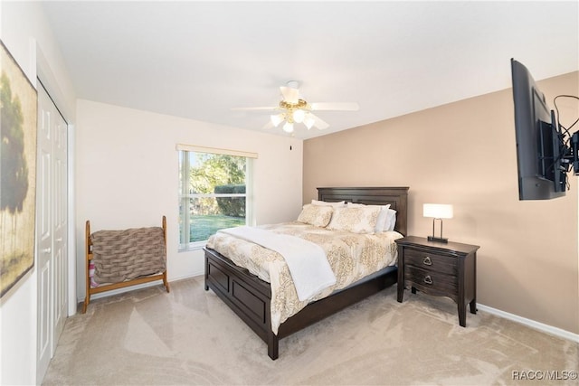 carpeted bedroom featuring ceiling fan and a closet