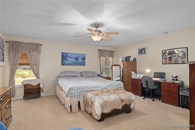 bedroom with light carpet, ceiling fan, and a textured ceiling