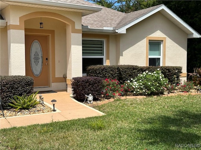 entrance to property with a lawn