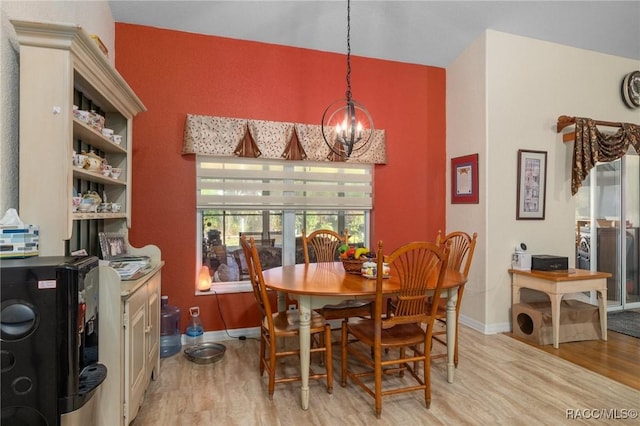 dining space featuring light wood-type flooring and a notable chandelier