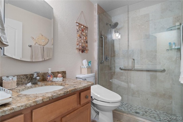 bathroom featuring vanity, toilet, and a shower with door