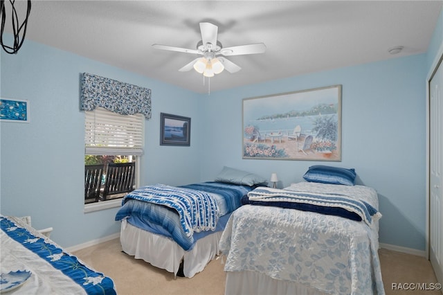 bedroom with ceiling fan, light carpet, and a closet