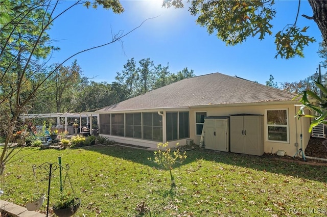 rear view of house featuring a lawn and a sunroom