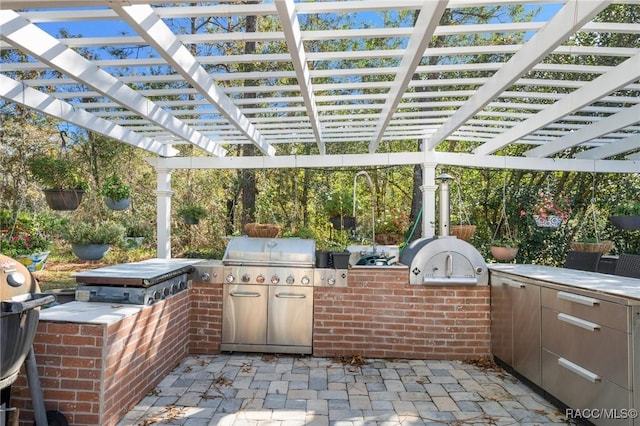 view of patio with a pergola, exterior kitchen, and grilling area