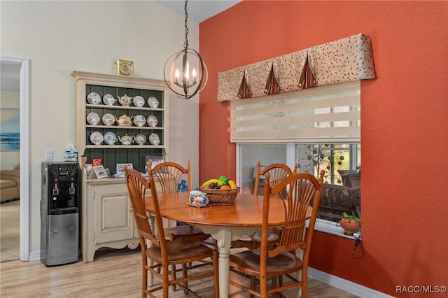 dining space with wood-type flooring and an inviting chandelier