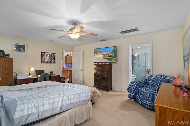 carpeted bedroom with ensuite bathroom and ceiling fan