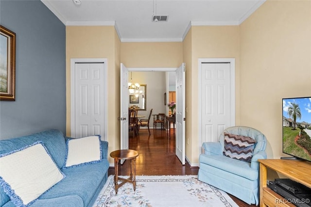 living room featuring ornamental molding, dark hardwood / wood-style floors, and a notable chandelier