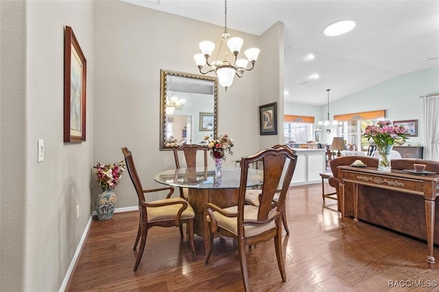 dining space featuring wood-type flooring, vaulted ceiling, and a chandelier