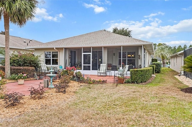 rear view of property with a patio, a sunroom, and a lawn