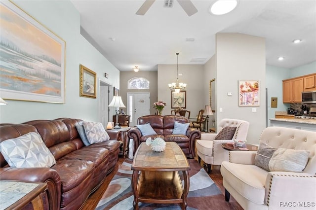 living room with dark wood-type flooring and ceiling fan with notable chandelier