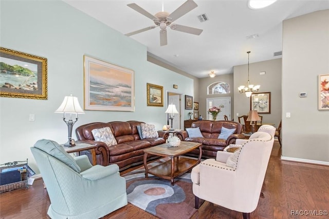 living room with dark wood-type flooring and ceiling fan with notable chandelier