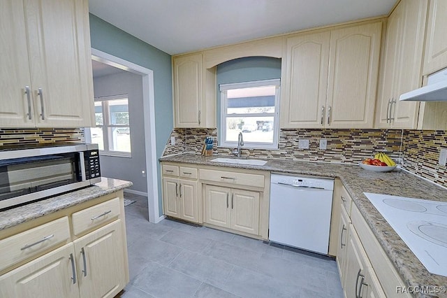 kitchen featuring plenty of natural light, sink, white appliances, and decorative backsplash