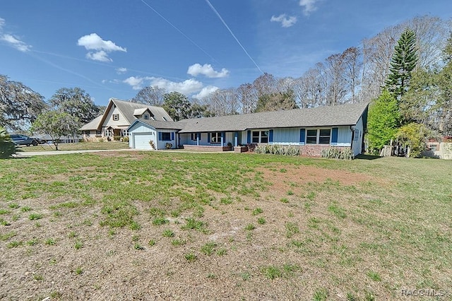 ranch-style house featuring a garage and a front lawn