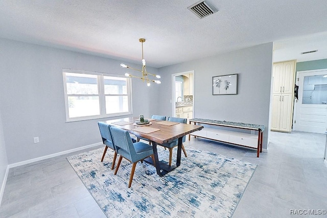 dining space with an inviting chandelier and a textured ceiling