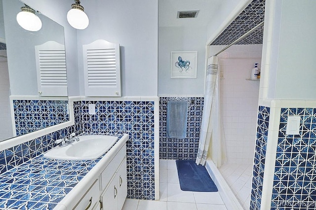 bathroom with vanity, tile walls, tile patterned floors, and walk in shower