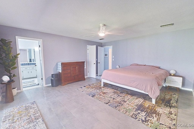 bedroom with ceiling fan, connected bathroom, and a textured ceiling