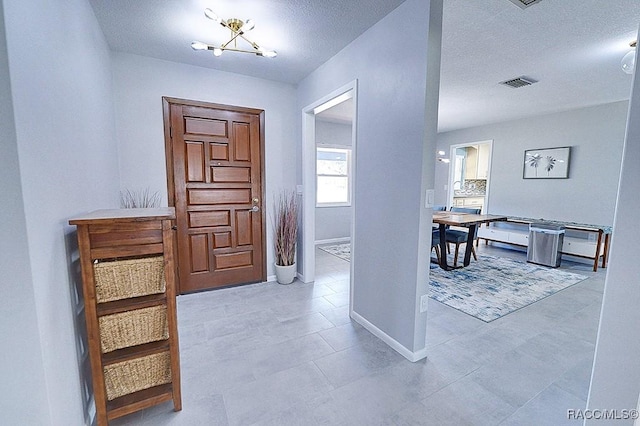 hall featuring a textured ceiling