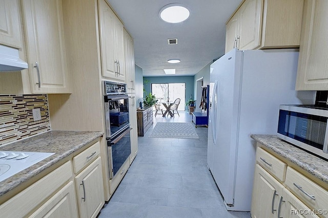 kitchen featuring light stone counters, appliances with stainless steel finishes, and decorative backsplash