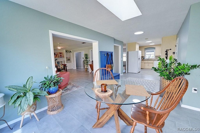 tiled dining room with a skylight