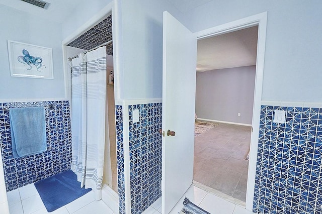 bathroom featuring tile walls, tile patterned flooring, and curtained shower