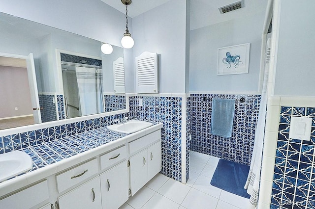 bathroom with tile patterned flooring, vanity, and tile walls