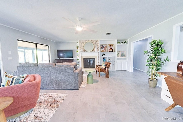 living room featuring crown molding, a large fireplace, and ceiling fan