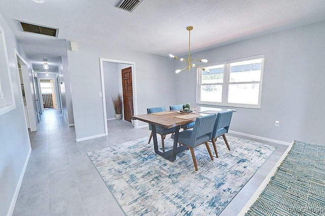 dining area with a textured ceiling and a chandelier