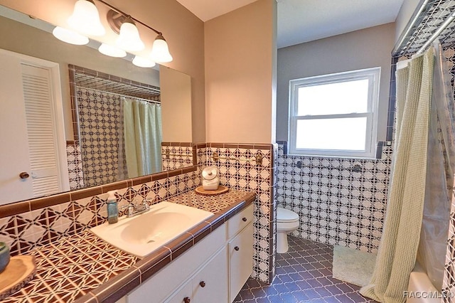 bathroom with vanity, tile walls, tile patterned floors, and toilet