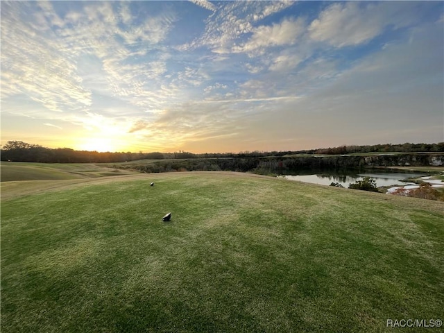 yard at dusk featuring a water view