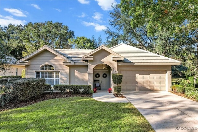 ranch-style home featuring a garage and a front yard