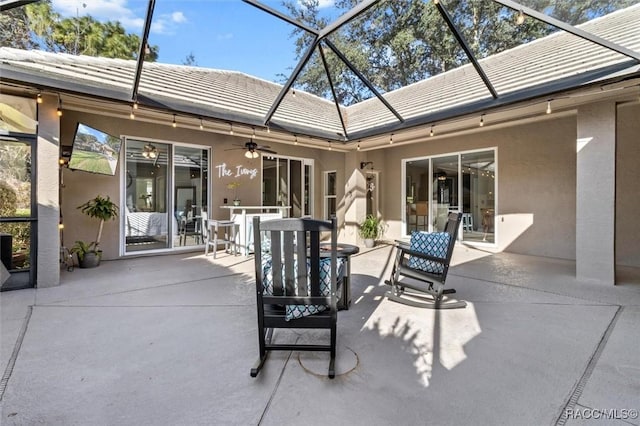 view of patio featuring ceiling fan and a lanai