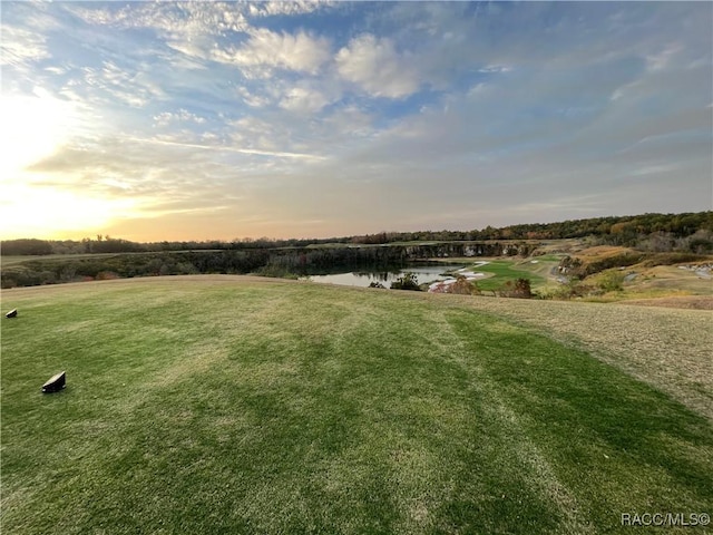 yard at dusk featuring a water view