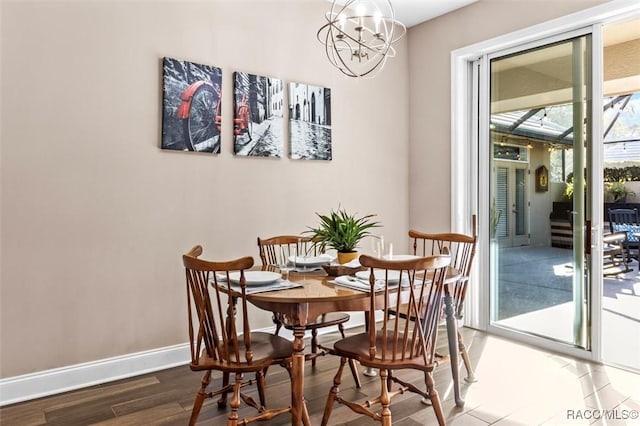 dining room with dark wood-type flooring and a notable chandelier