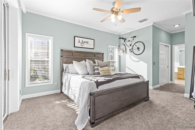 bedroom featuring carpet, ensuite bath, ceiling fan, and crown molding