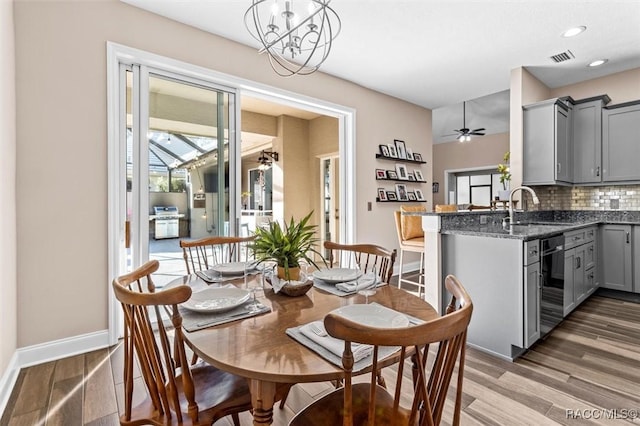 dining room featuring wine cooler, sink, dark wood-type flooring, and ceiling fan with notable chandelier