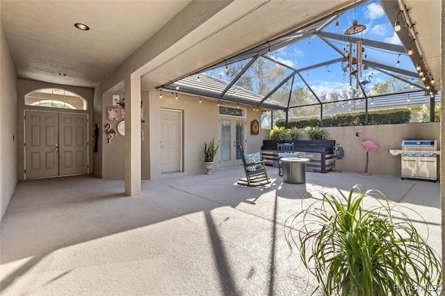 view of patio featuring a lanai, a grill, a jacuzzi, and french doors