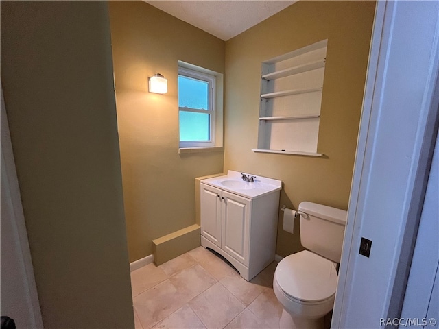 bathroom featuring tile patterned flooring, vanity, and toilet