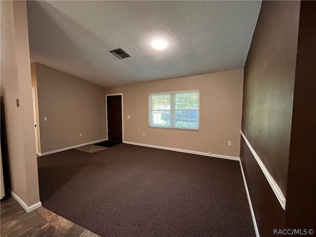 carpeted empty room featuring a textured ceiling