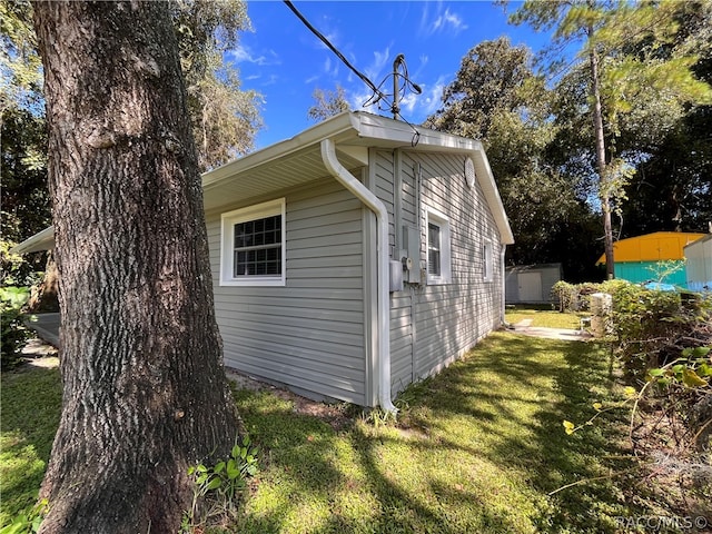 view of property exterior with a storage unit and a yard