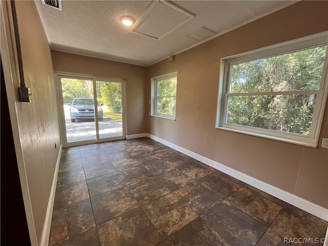 unfurnished room with a textured ceiling