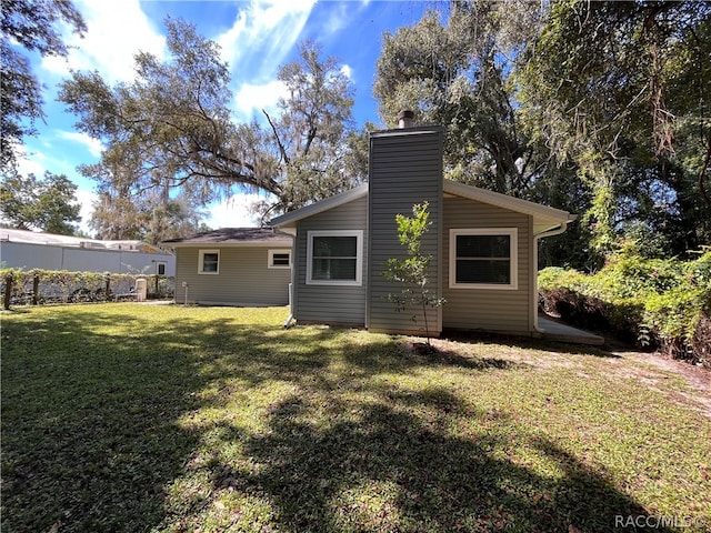 rear view of property featuring a yard