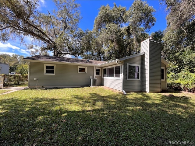 back of property with a lawn and central AC unit